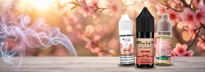 Three e-liquid bottles displayed on a wooden surface against a warm, blurred background of pink blossoms and smoke. The center bottle is black with a black cap and reads 'ELIX SOLUTIONS RED PUNCH', flanked by two smaller bottles with white and green labels.