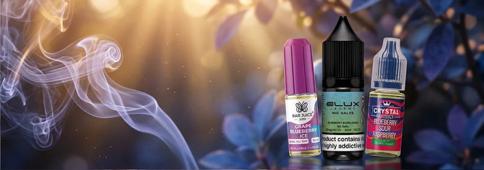 Three e-liquid bottles from ELUX and Crystal Headz are lined up against a dark, atmospheric background with blue leaves and a glowing golden light effect with smoke on the left.